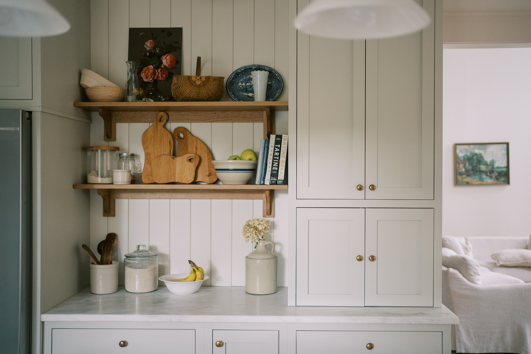 Shiplap feature wall in a kitchen with english cottage style shelving.