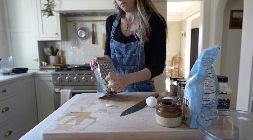 woman grating onion for slow cooker meatballs