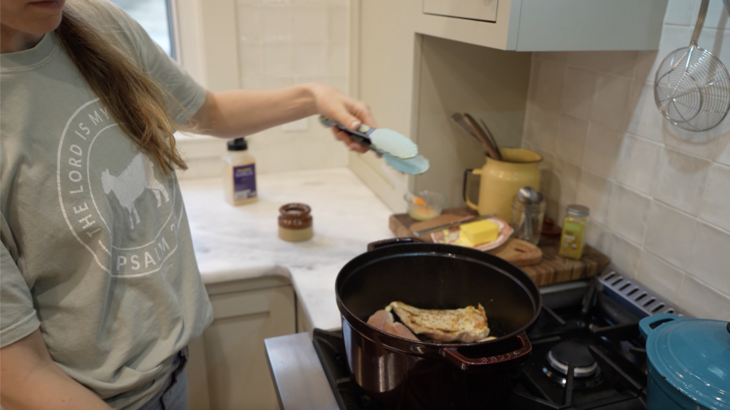 woman searing chicken breasts in a stuab 