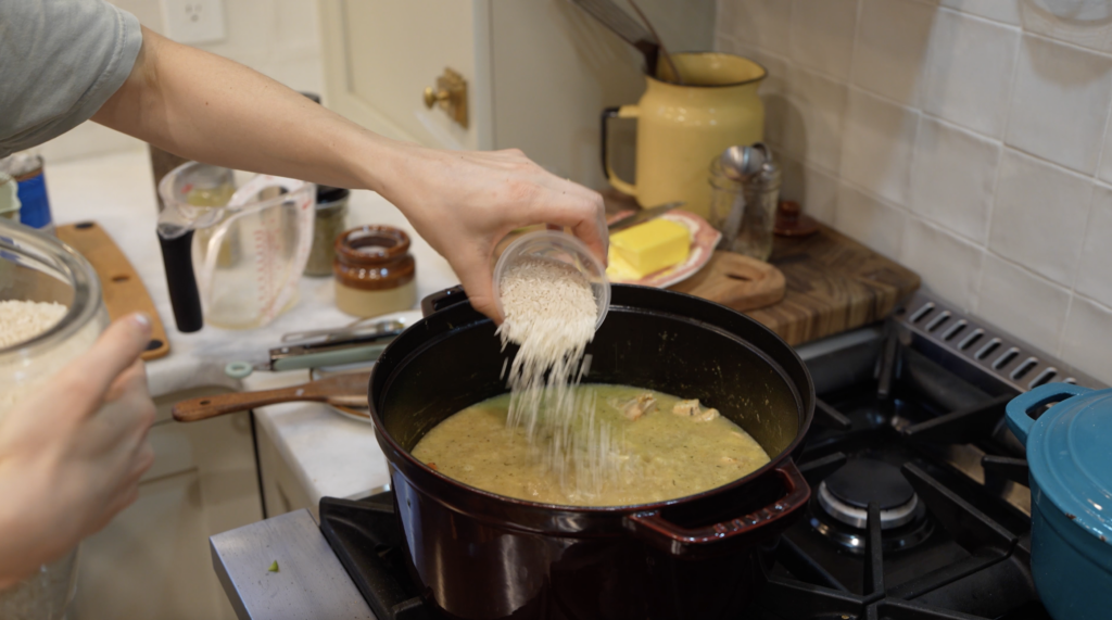 woman adding rice to a pot for a chicken pot pie rice skillet