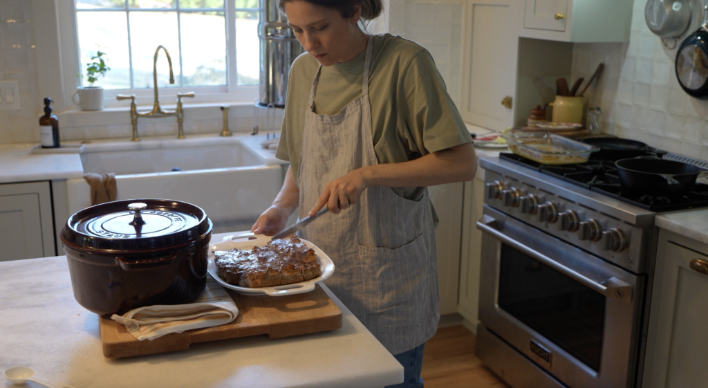 woman cutting up healthy meatloaf in a cozy kitchen