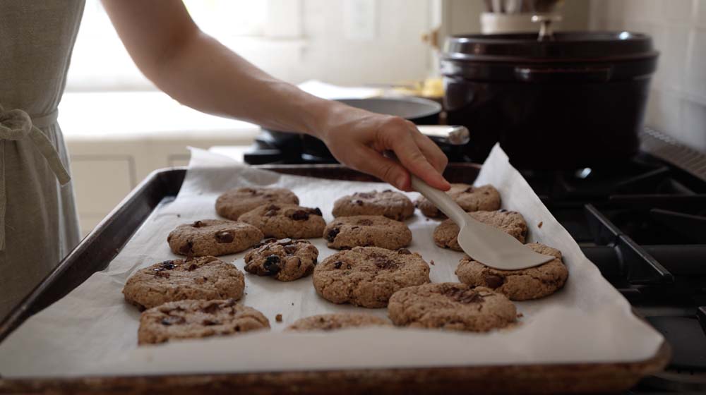 woman pressing down breakfast cookies with a spatula