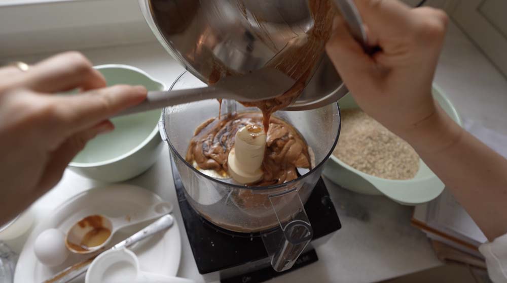 Someone making breakfast cookies in a food processor