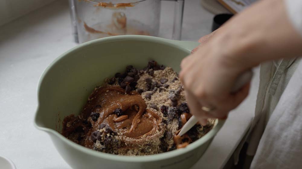Woman mixing up healthy ingredients for breakfast cookies