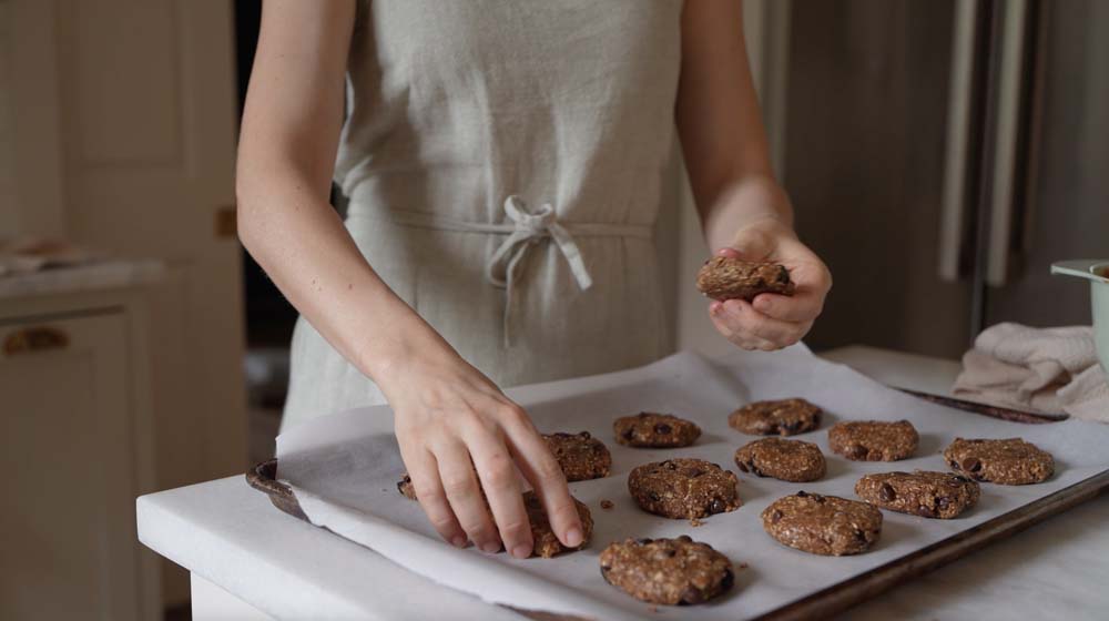 woman making breakfast cookies and shaping them on a sheet pan