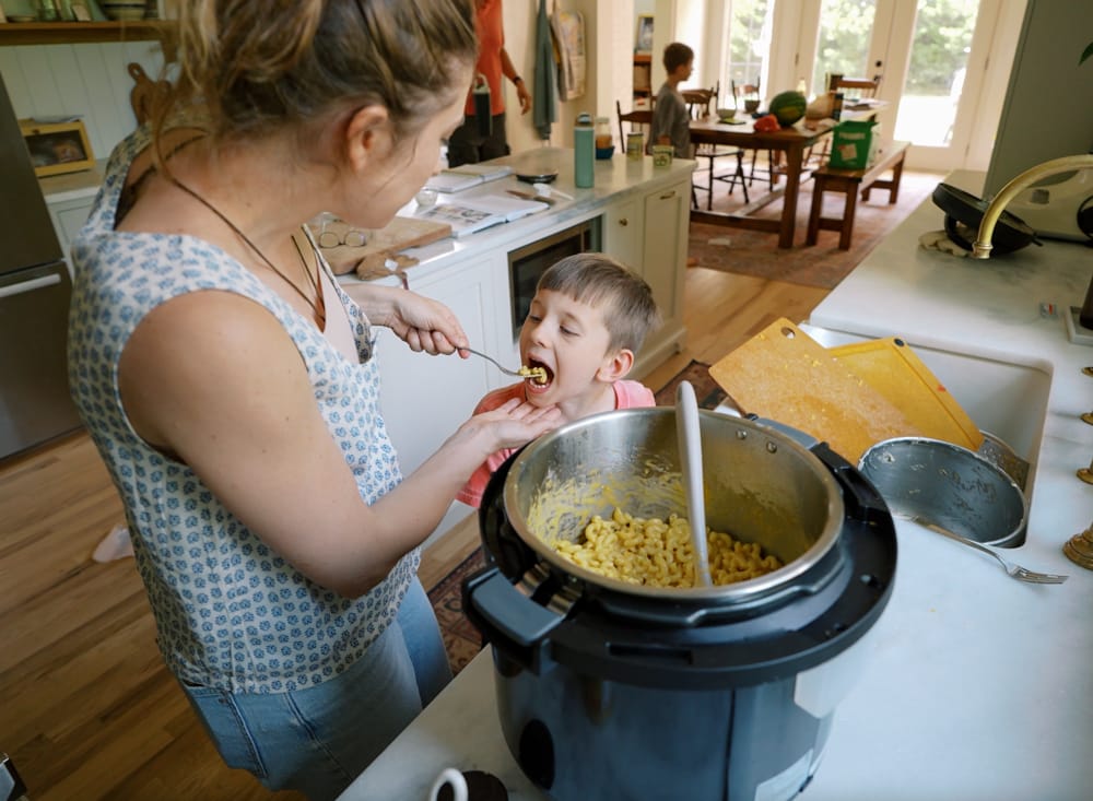 woman feeding child instant pot mac and cheese