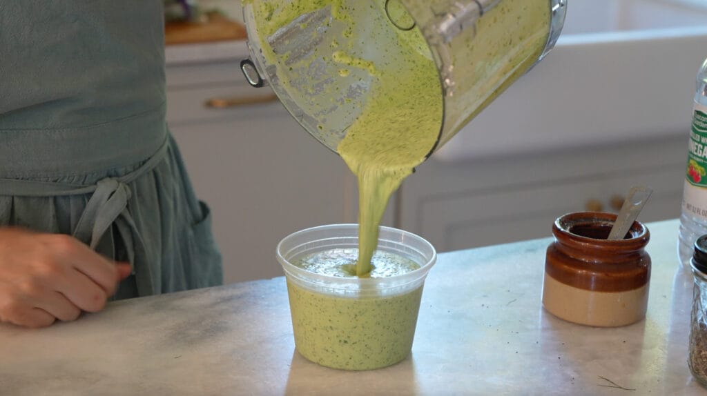 homemade jalapeno ranch slaw being poured into container for easy meal prep