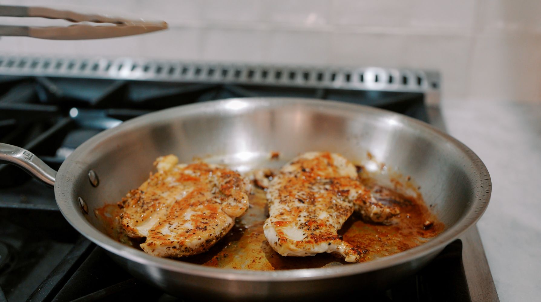 perfectly cooked chicken on a stainless steel skillet
