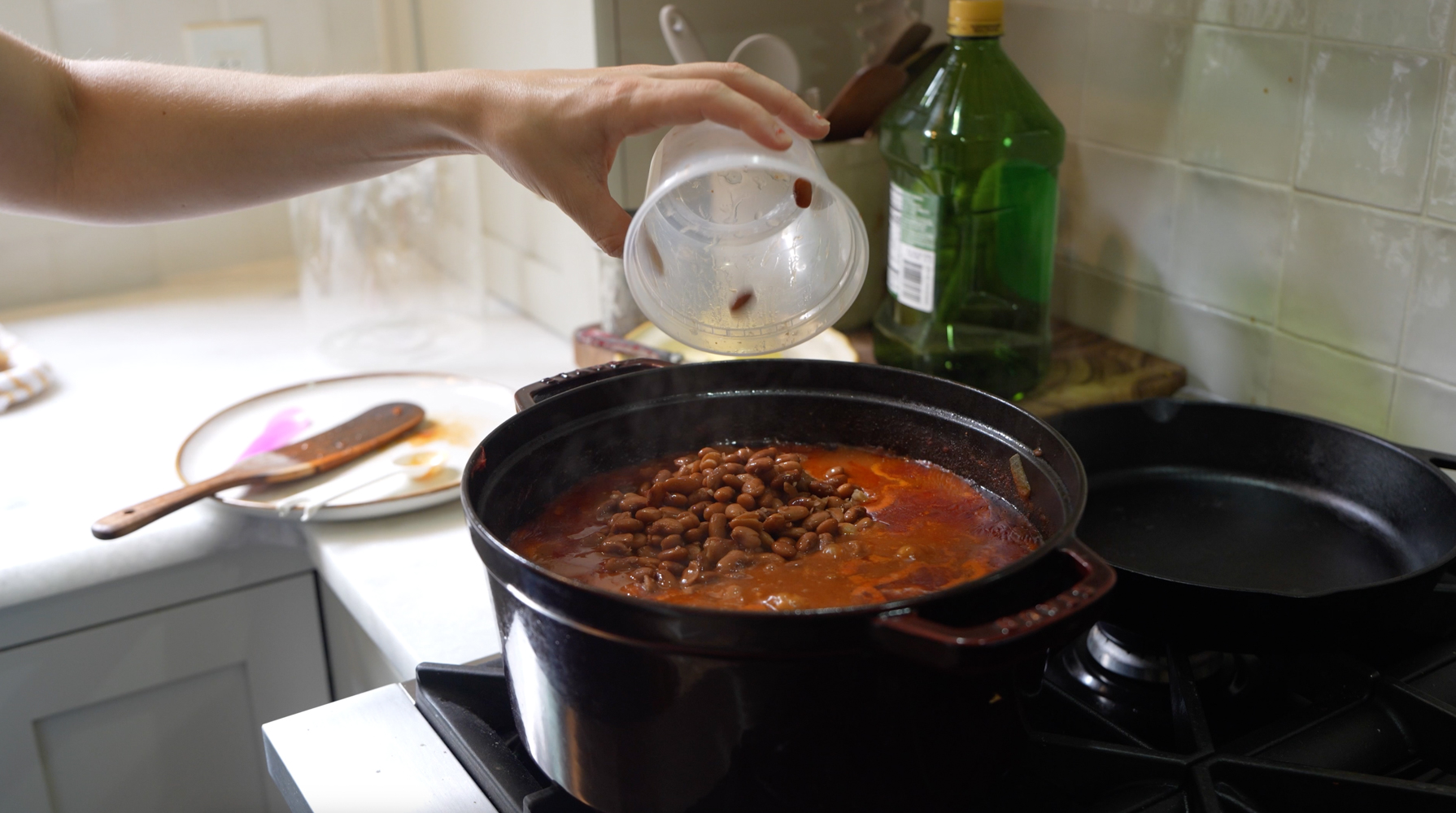 adding beans to simmering chili