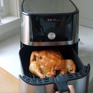 Whole roasted chicken cooked in an air fryer on the counter