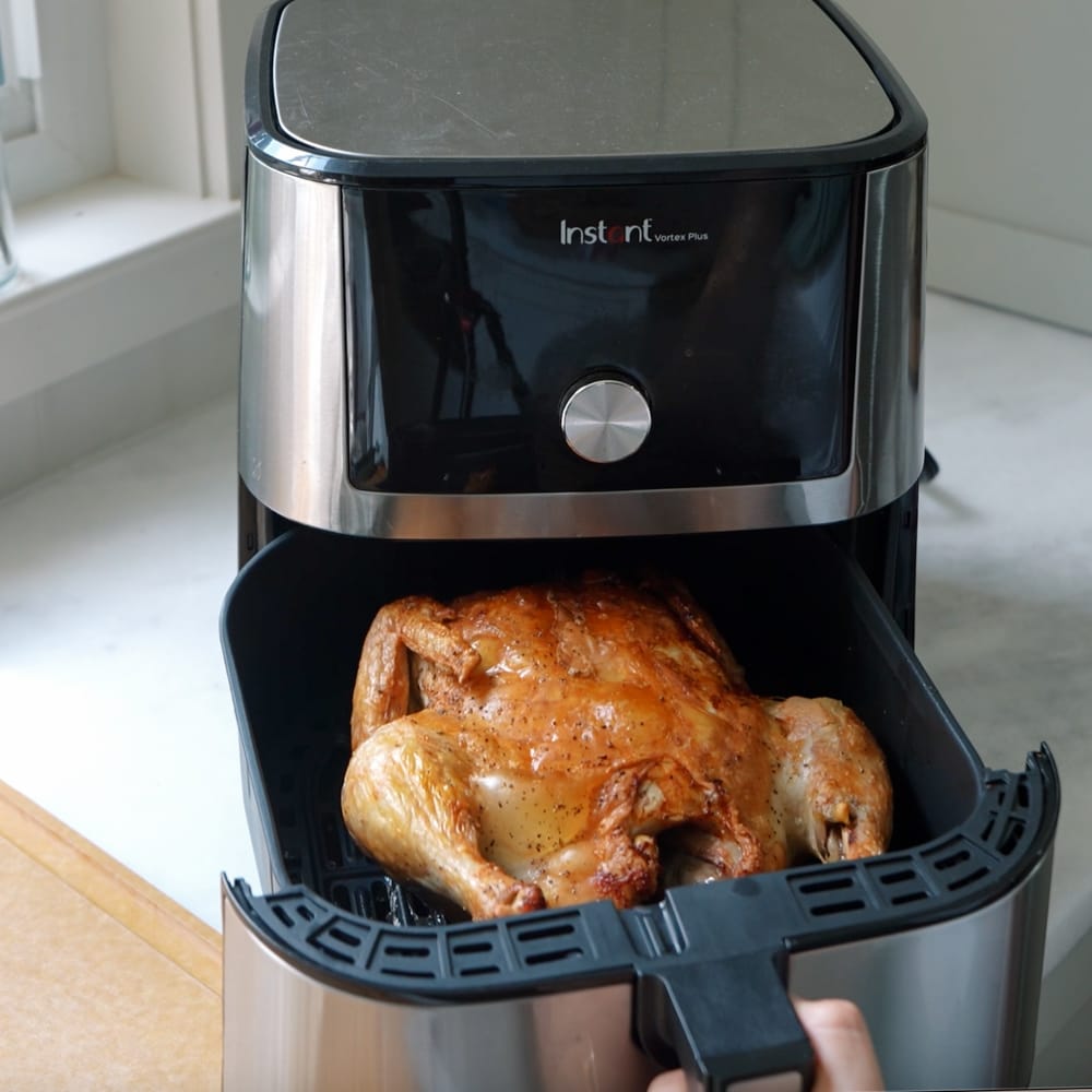 Whole roasted chicken cooked in an air fryer on the counter