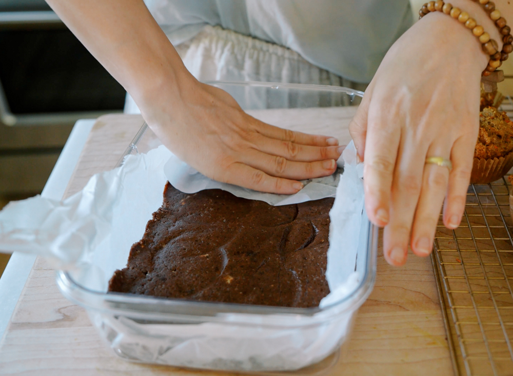 pressing downhomemade chocolate rx bars in a containers