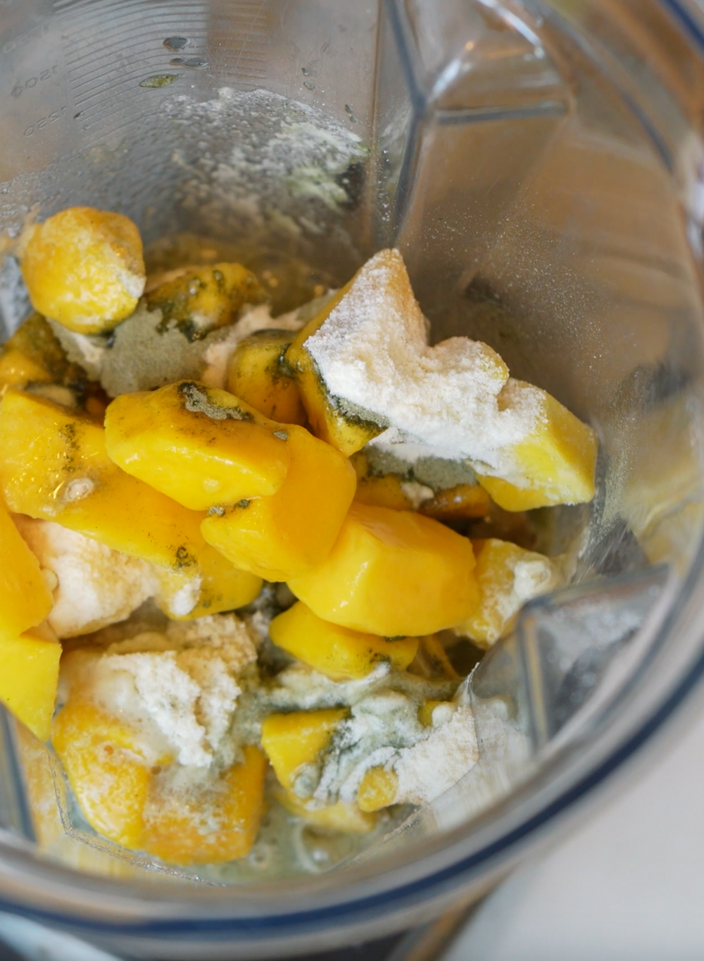 mango and clean simple eats protein in a blender