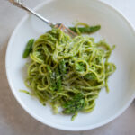 green pasta with arugula, pesto, pistachios and asparagus