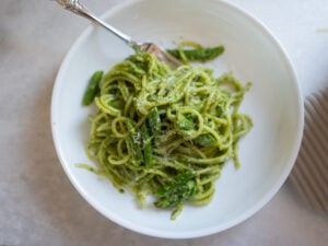 green pasta with arugula, pesto, pistachios and asparagus