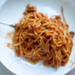 a delicious plate of spaghetti with sausage and carrots