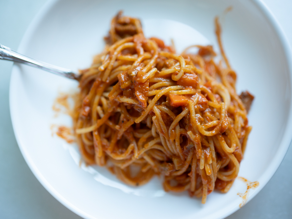 a delicious plate of spaghetti with sausage and carrots